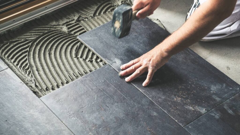 worker installing floor tiles