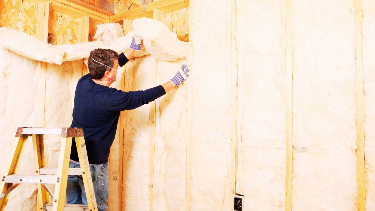 guy installing an insulation on a wall