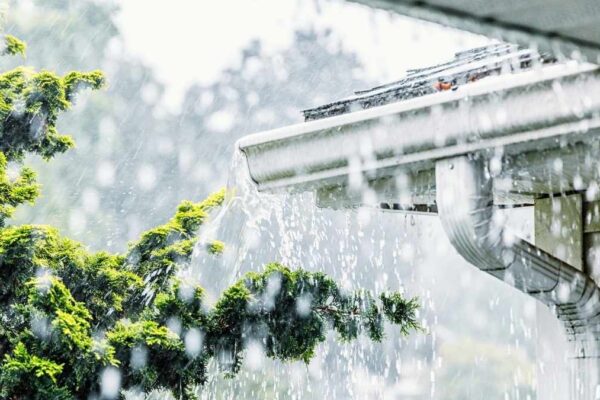 water pouring out of the gutter due to heavy rain