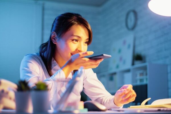 Woman providing instruction to a voice assistant through mobile phone