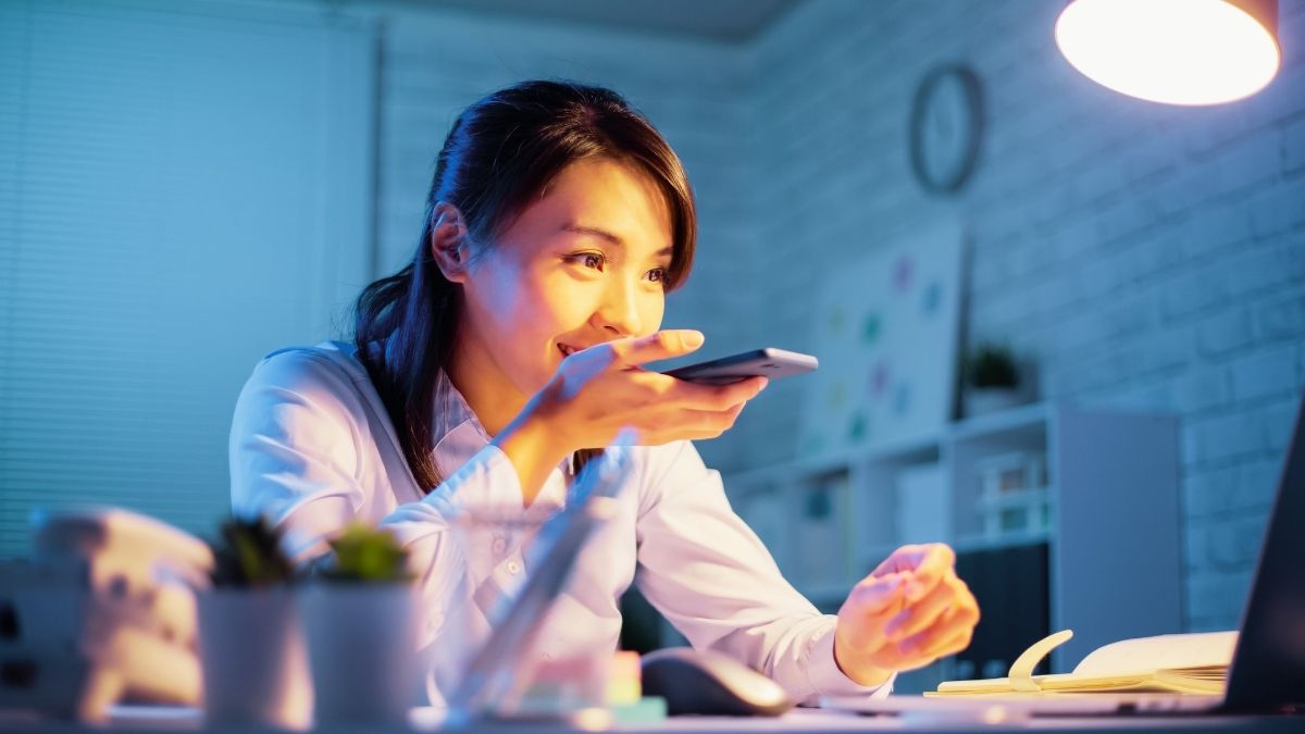 Woman providing instruction to a voice assistant through mobile phone