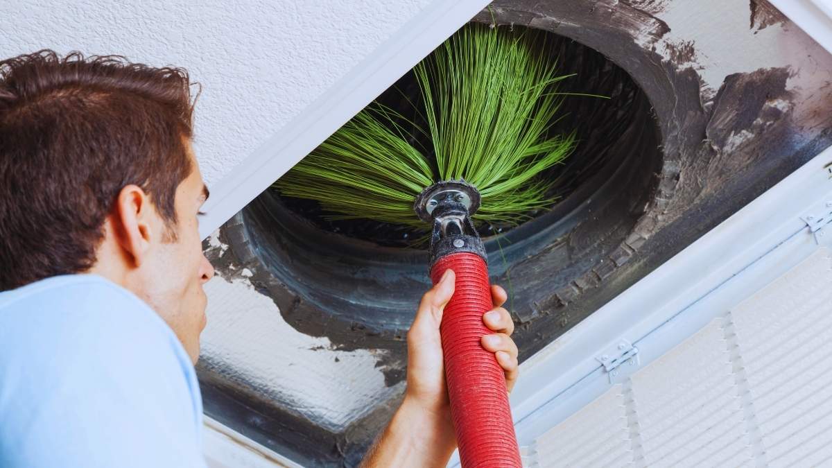 a person cleaning an air duct