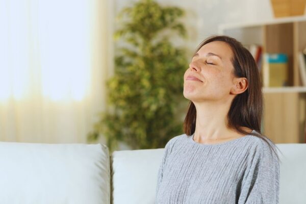 Woman sniffing in the air inside her home.